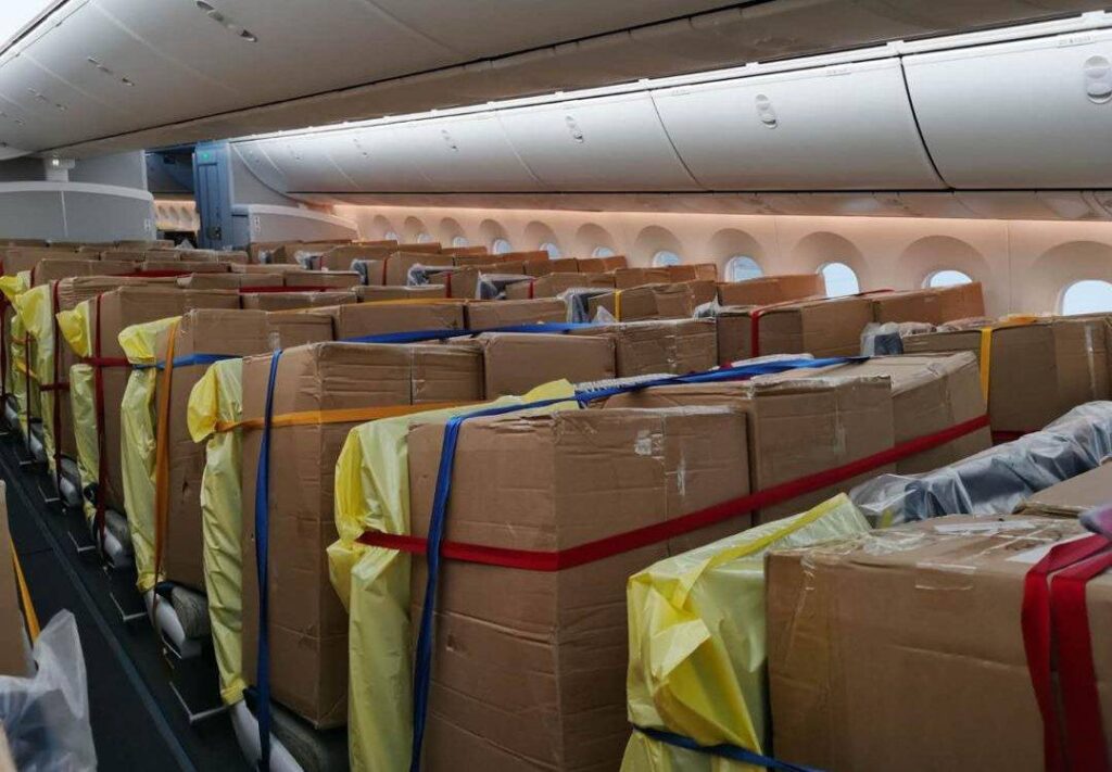 carga aérea 2025: bodega de avión con paquetes de e-commerce y carga consolidada